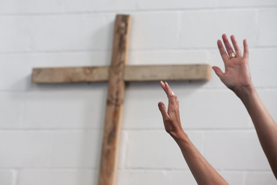 Worshippers praise and worship infront of the Holy Cross